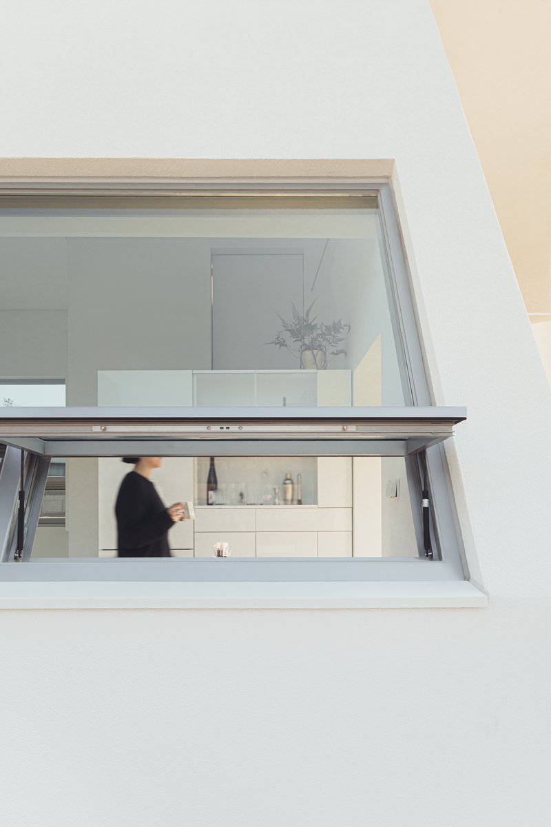 Kitchen pass-through window with glass folding doors and a figure moving inside