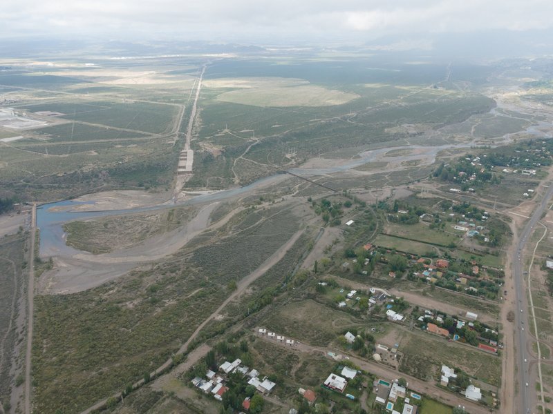 Wide aerial view showing the housing cluster within a patchwork landscape of roads and waterways