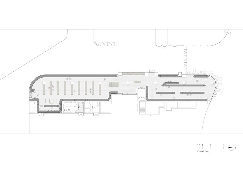 Floor plan drawing depicting a curved retail space with shelving layout and circulation paths