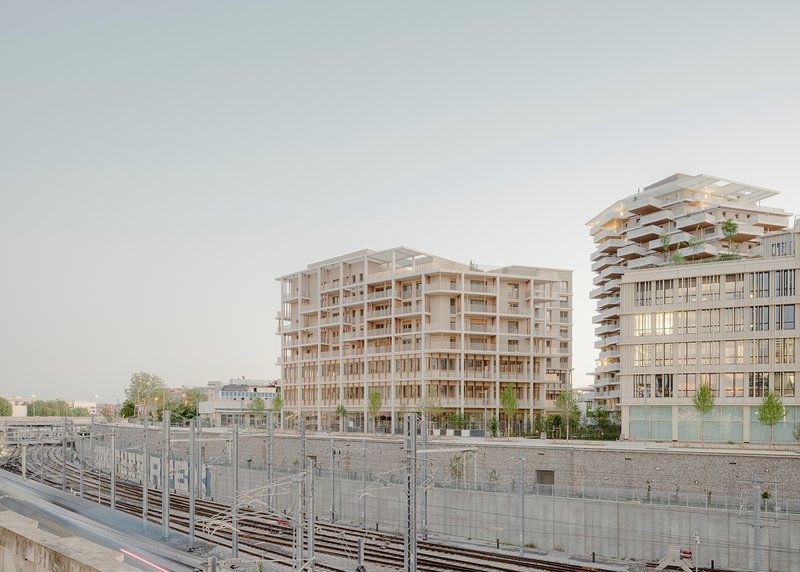 View of the timber-framed residential buildings from the railway tracks under an overcast sky
