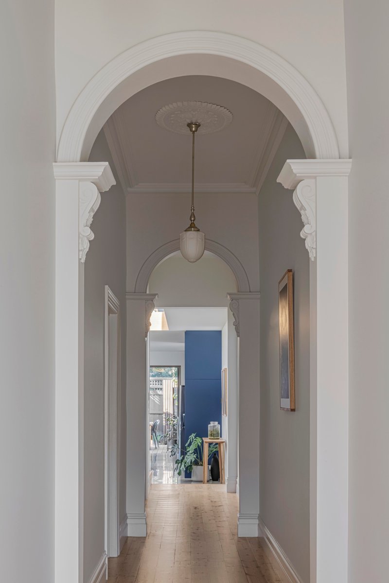Enfilade of arched doorways with pendant light leading through the hallway to a blue room