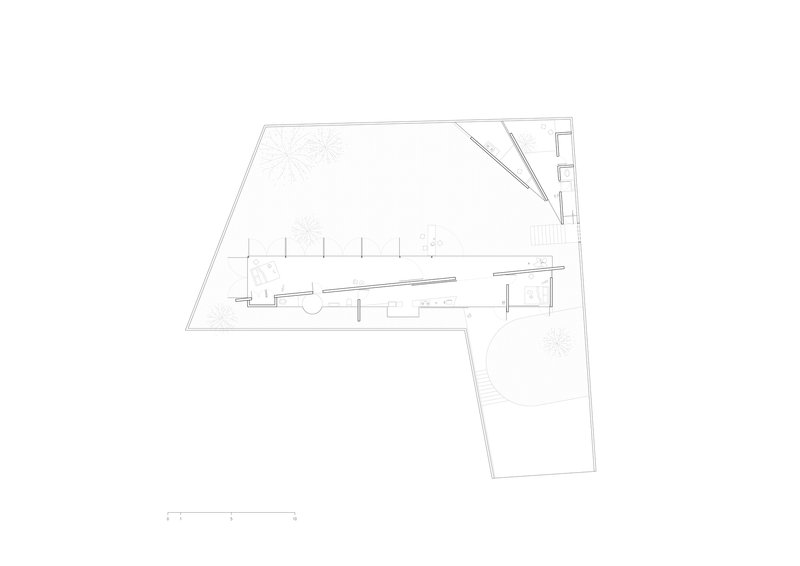 Site plan drawing showing linear building volumes arranged around gravel courtyards