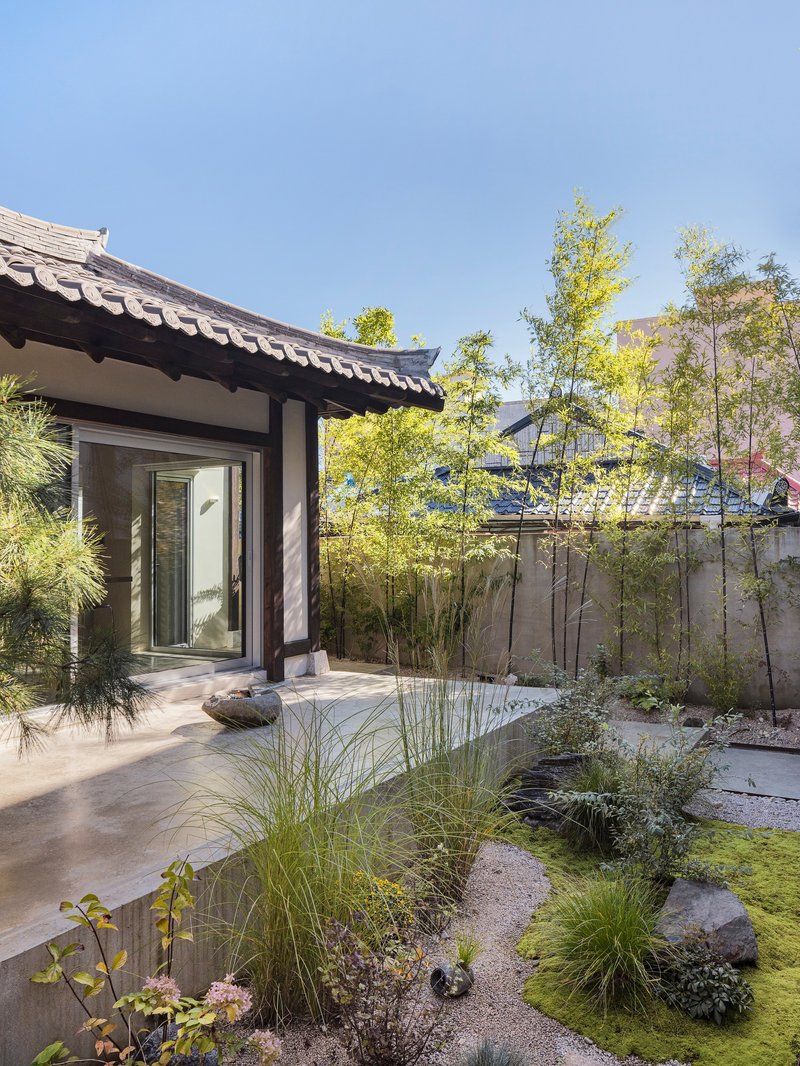 Courtyard garden with gravel, rocks, grasses and bamboo outside the entrance doorway