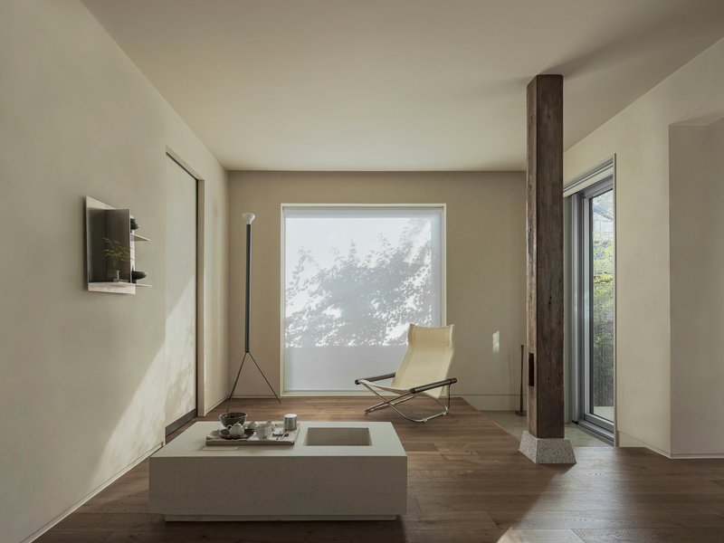 Living space with a low table, lounge chair, and translucent screen filtering tree shadows