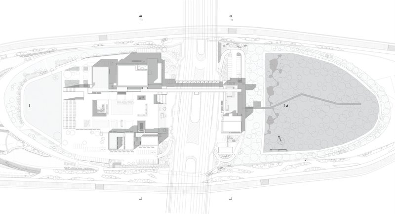 Site plan drawing showing building clusters bisected by a central roadway and adjacent park