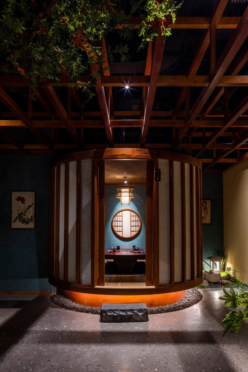 Interior view through the curved entry vestibule showing a circular window and pendant light in the foyer beyond