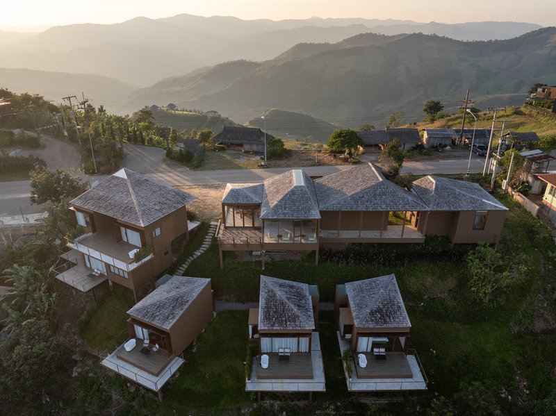 Drone view of the compound at dusk with rolling hills and mist in the background