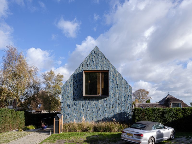 Front elevation of the tiled gable with central window under shifting clouds
