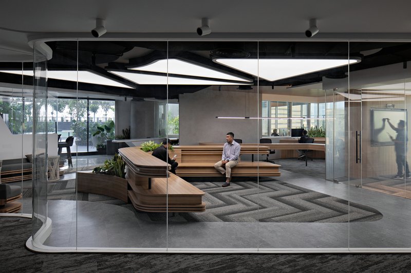 Reception lounge with tiered timber benches viewed through floor-to-ceiling glass wall