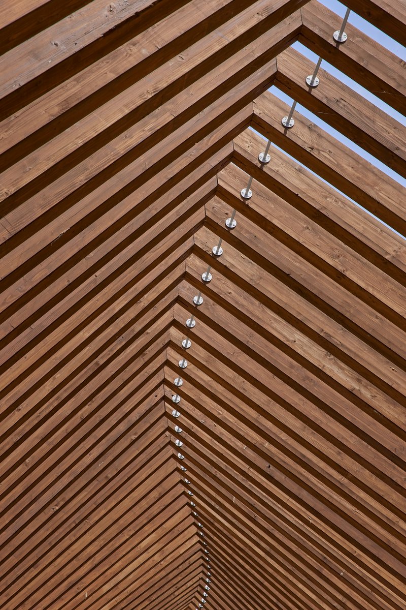 Close-up of the timber slat ceiling showing steel connectors along the ridge