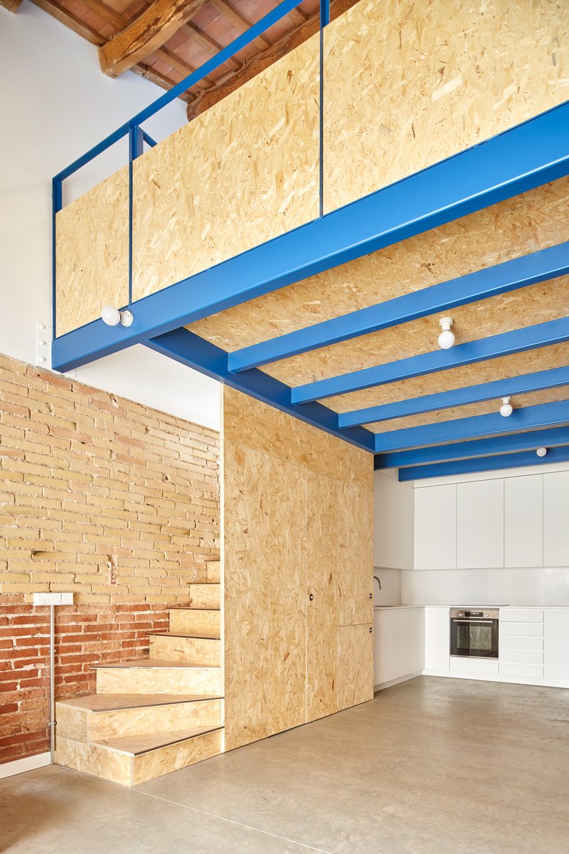 Mezzanine level with oriented strand board cladding and blue steel frame above kitchen area
