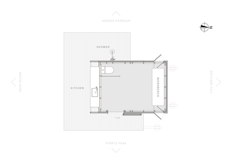 Floor plan drawing showing a compact layout with shower, kitchen, and workspace around a central room