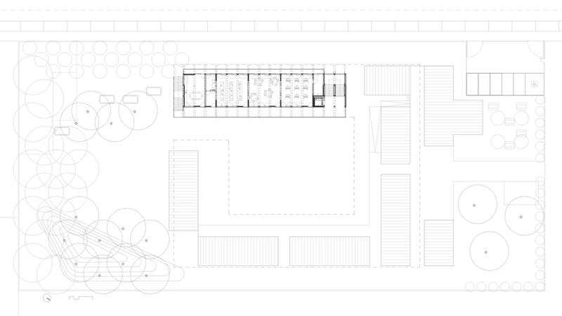 Site plan drawing showing a linear building with courtyard surrounded by landscaped areas and trees