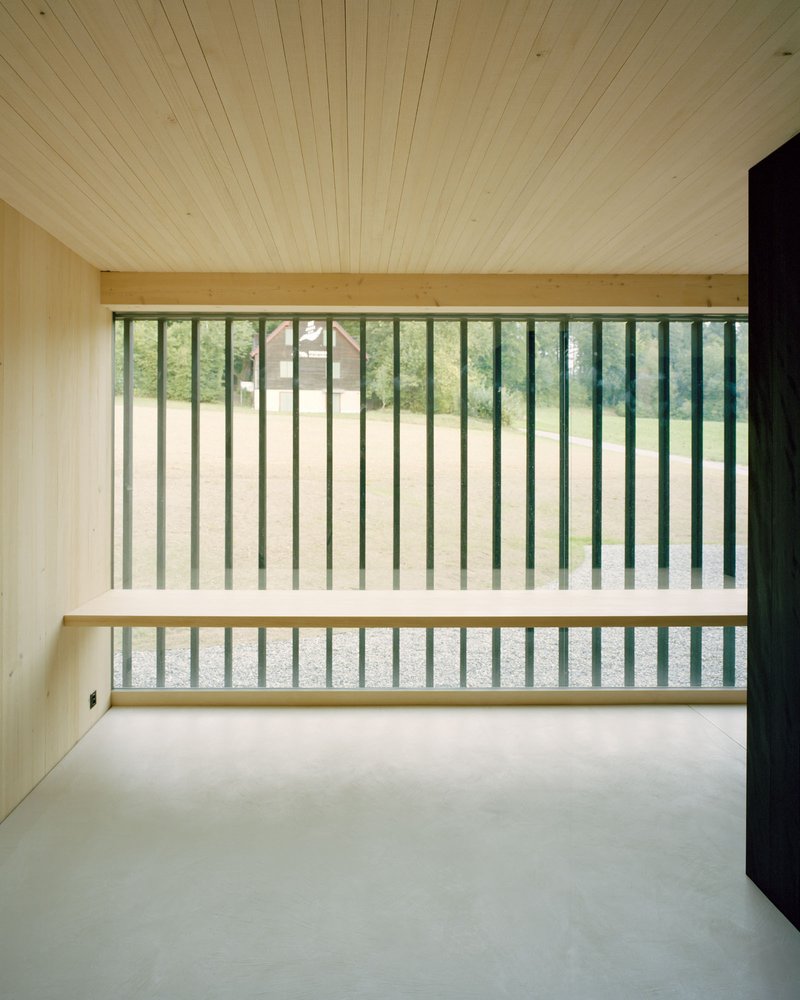 Upper-level room with vertical timber louvers framing a view to an open landscape beyond