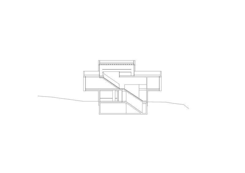 Section drawing showing split-level volumes with diagonal stair connecting multiple floors on sloping terrain