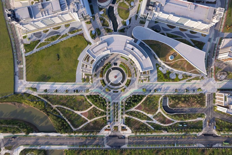 Drone view of circular plaza with concentric pavers leading to pedestrian pathways and green spaces