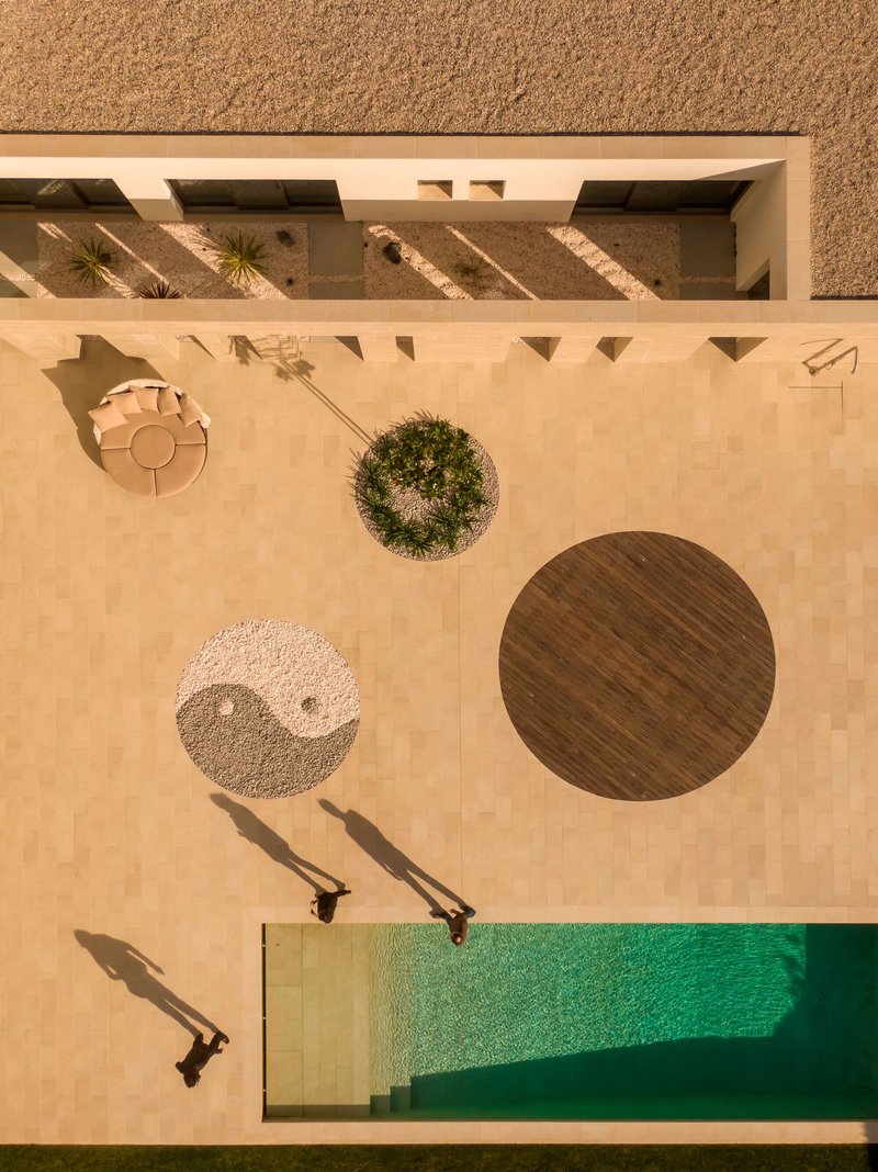Overhead view of terrace showing circular planters timber deck and pool corner casting afternoon shadows