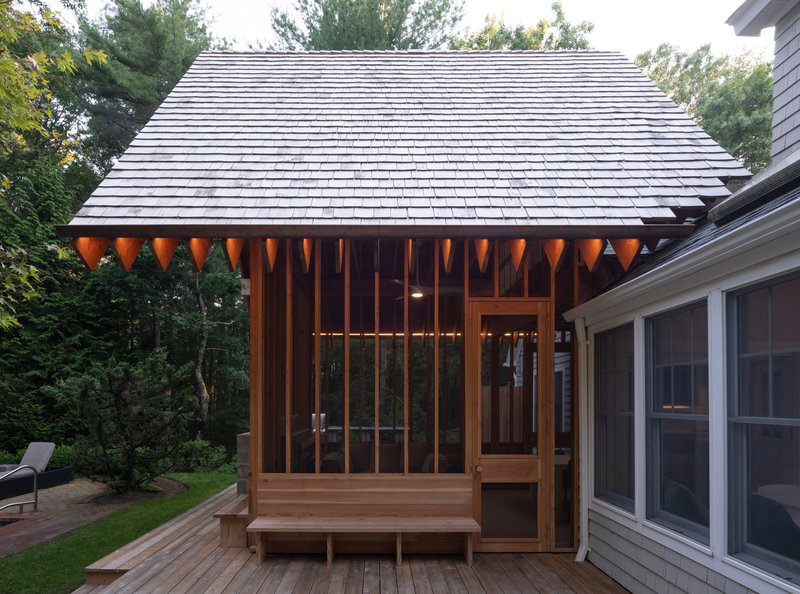 Close-up of the timber pavilion roof eave with exposed rafter tails and vertical wood screen