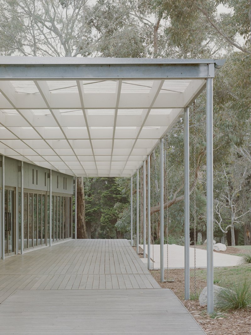 Covered timber deck along glazed facade with steel column frame and translucent ceiling panels