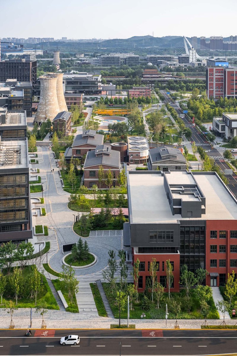 Elevated view of the tree-lined campus streets with red brick buildings and industrial structures beyond