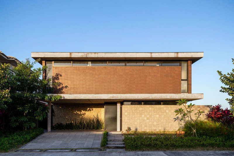 Street facade with terracotta tile upper volume and cantilevered concrete slab above a recessed carport entrance