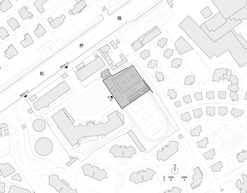 Site plan drawing showing a rectangular building footprint within a campus of smaller structures