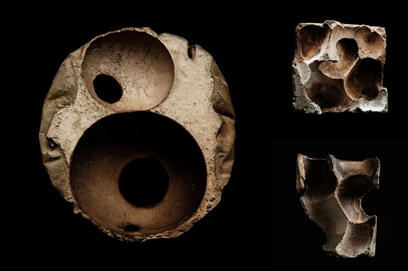 Three fired ceramic test pieces showing circular perforations and organic cavities