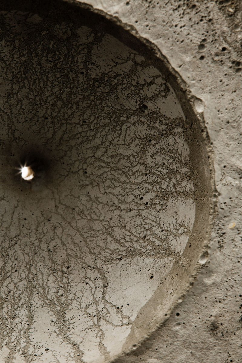 Interior view looking up into one of the curved concrete voids with textured surface