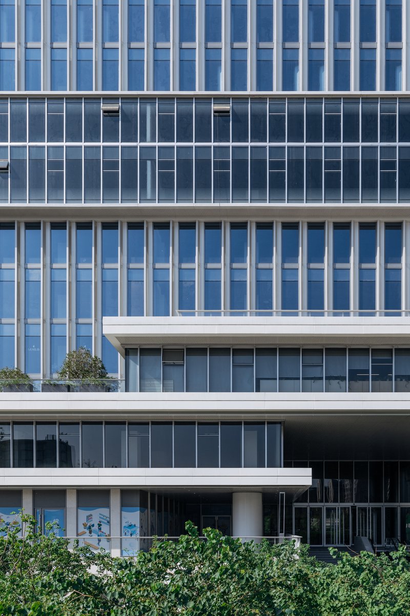 Layered horizontal glass and concrete facade with alternating vertical and horizontal fenestration patterns
