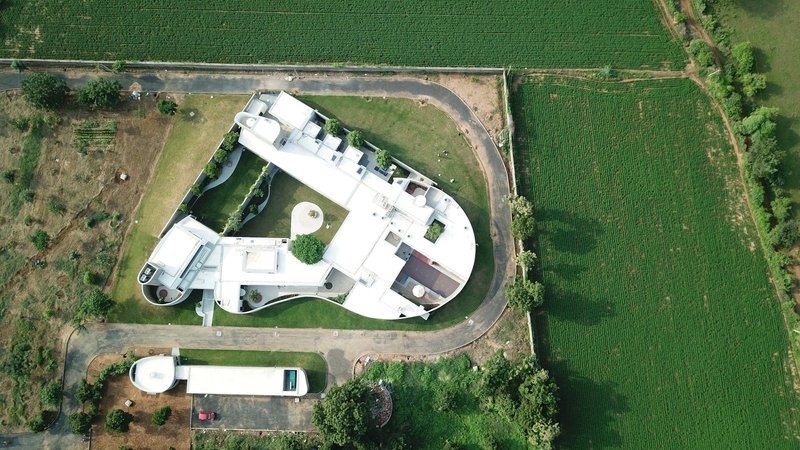 Aerial view of the curved white roof surrounded by agricultural fields and access roads