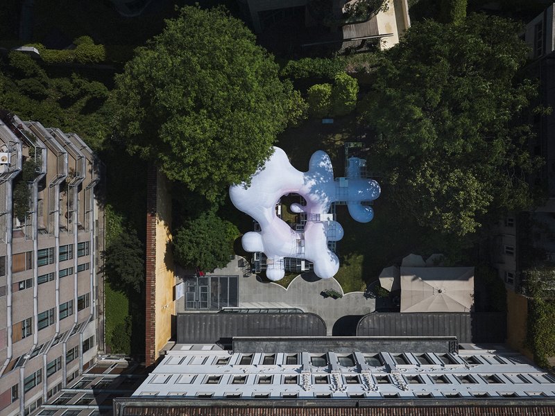Aerial view of the white inflatable pavilion with three bulbous lobes set among green trees