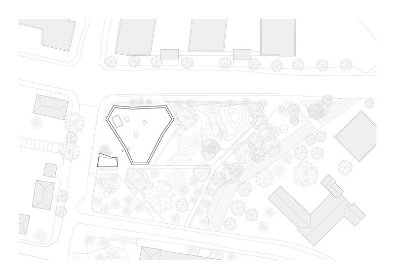 Site plan drawing showing pentagonal footprint within a landscaped campus and adjacent buildings