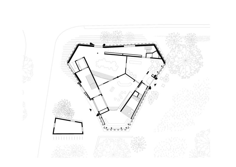 Site plan drawing showing a pentagonal building footprint with surrounding landscape and trees