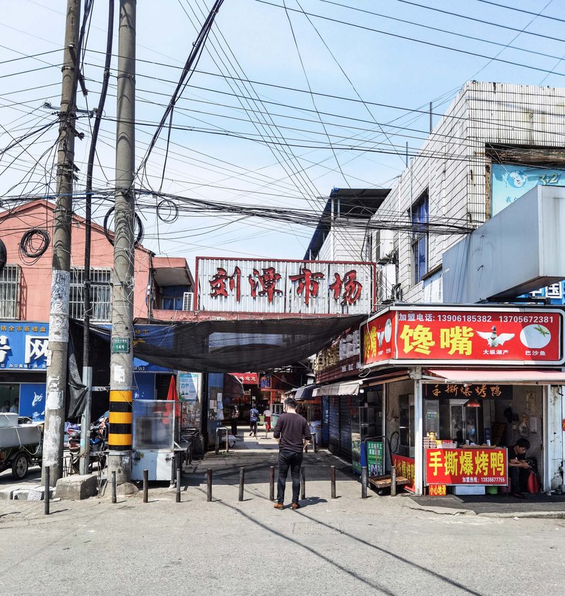 Elevated pedestrian bridge crossing a street intersection beneath tangled overhead power lines