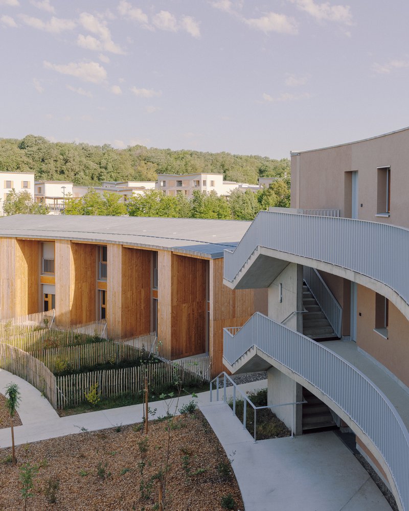 Aerial view of the curved courtyard with timber frames, metal roofing and planted landscape beds