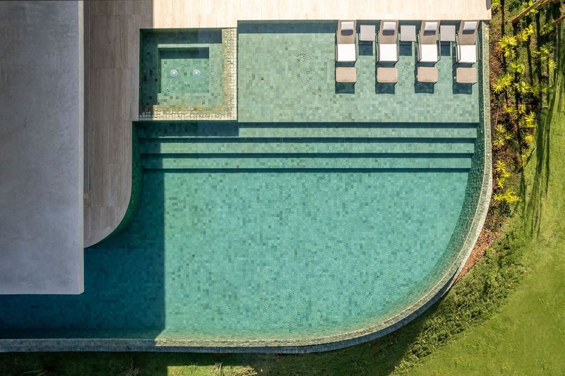 Aerial view of the curved pool with submerged steps and lounge chairs on the deck