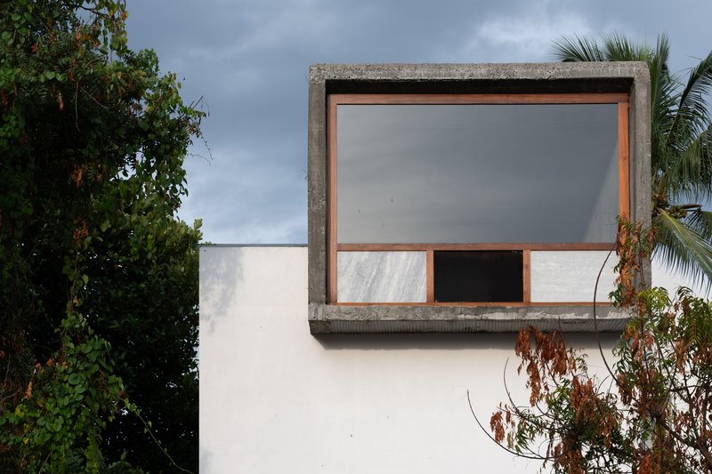 Concrete framed window box with timber trim and sliding panels against a white wall
