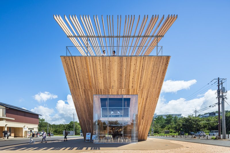 Front facade with angled timber walls and slatted timber pergola framing the rooftop terrace