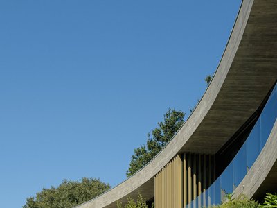 MUTANT Architecture Bends a Concrete Slab into a Hillside Embrace at Casa De Bouro