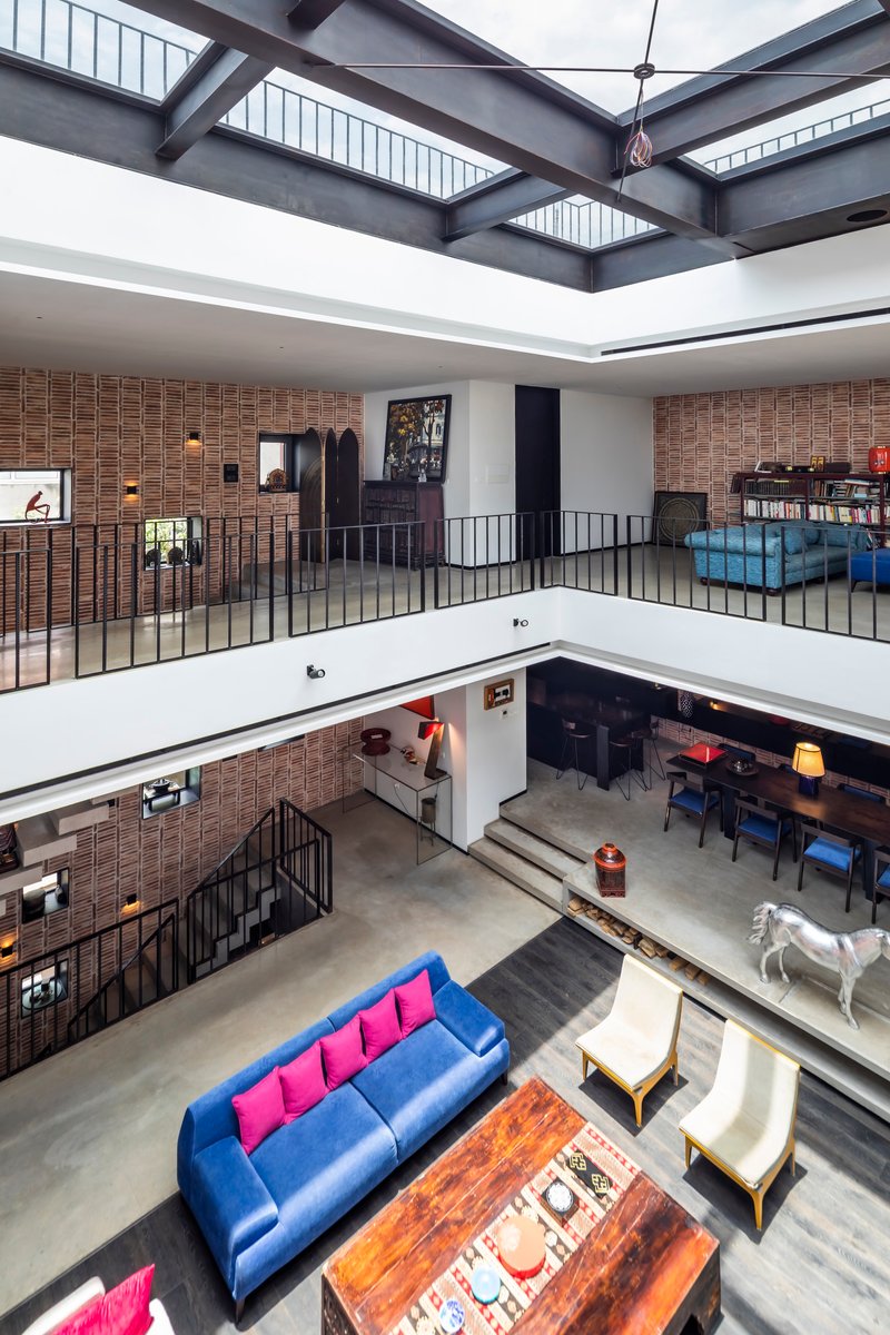 View across the central atrium showing stacked galleries with steel railings and skylight above