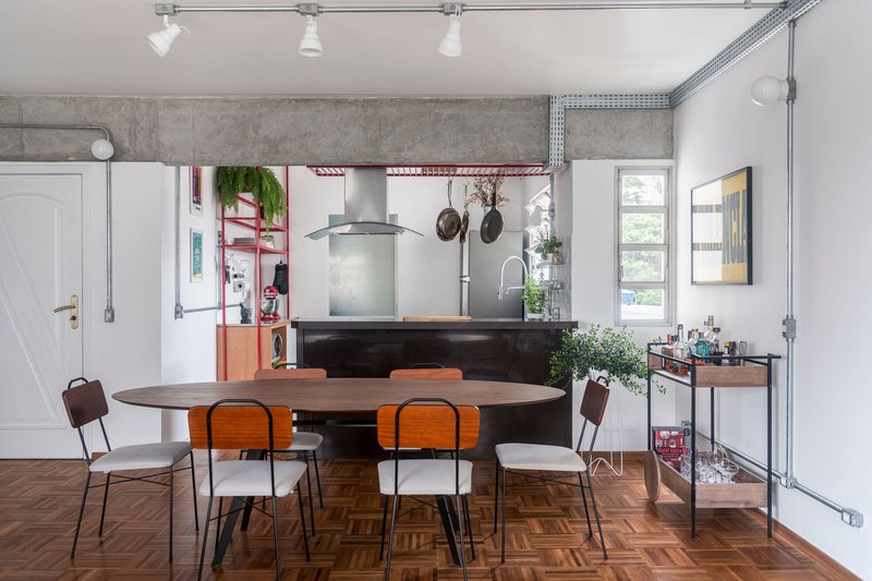 Open kitchen and dining area with exposed concrete beams and herringbone parquet flooring