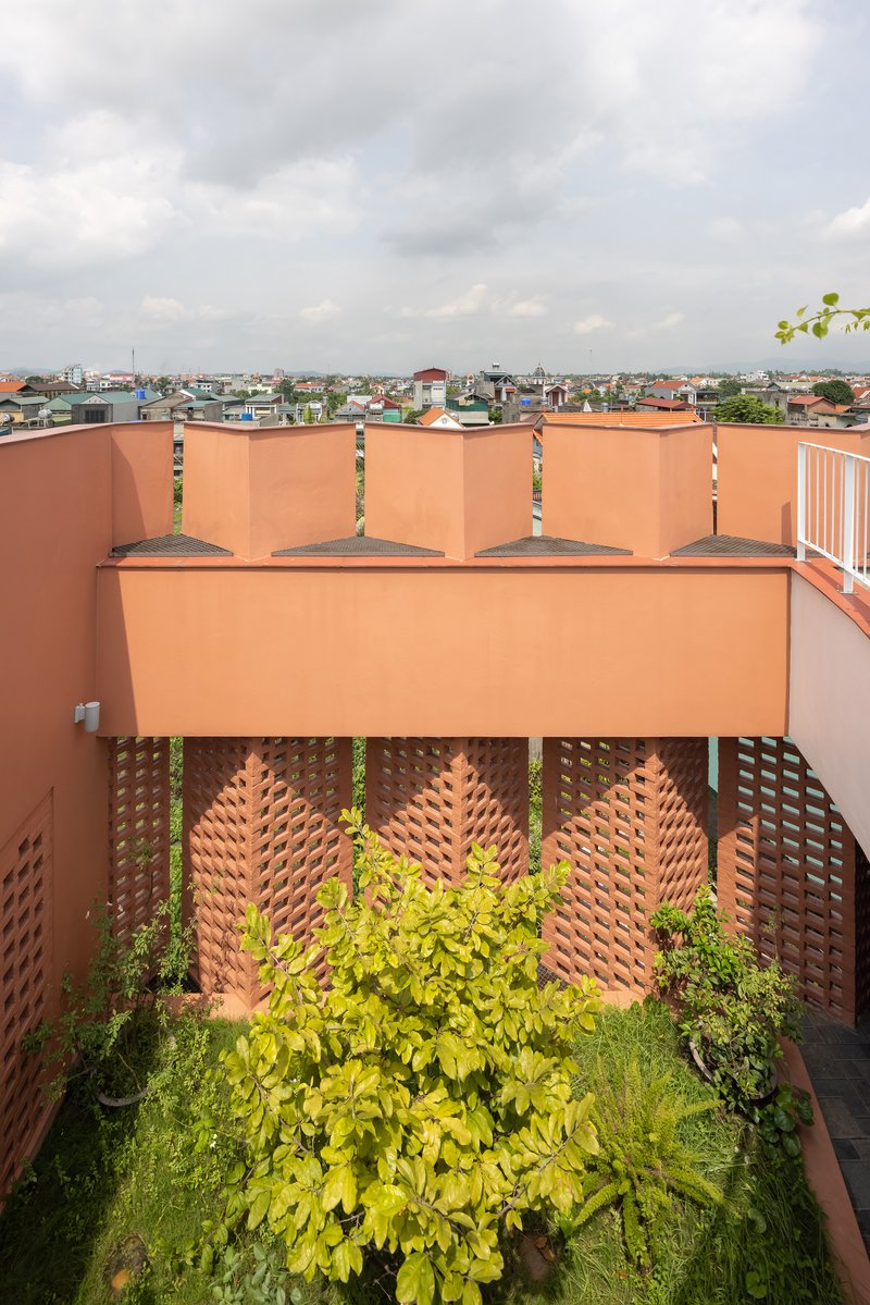 Rooftop terrace with perforated brick screens and planted bed overlooking the surrounding neighborhood