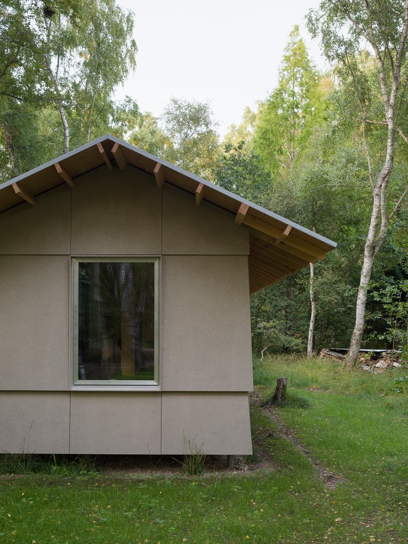 Corner detail of the gable end with exposed rafters and large glazed opening to the forest