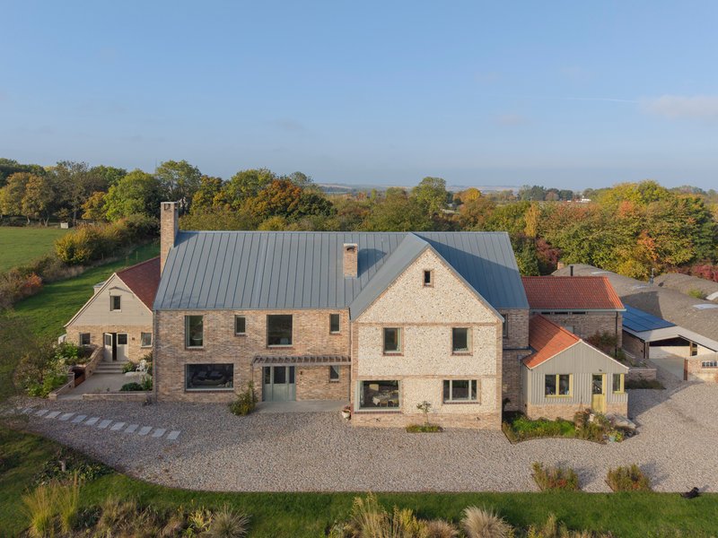Aerial view of the gravel courtyard and linked residential volumes surrounded by autumn foliage