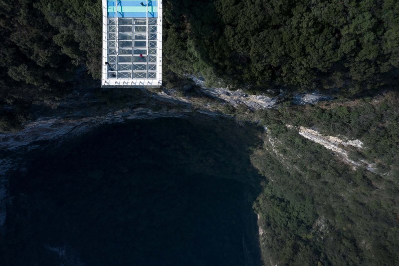 Overhead view of the rectangular glass roof structure at the cliff edge above dark water