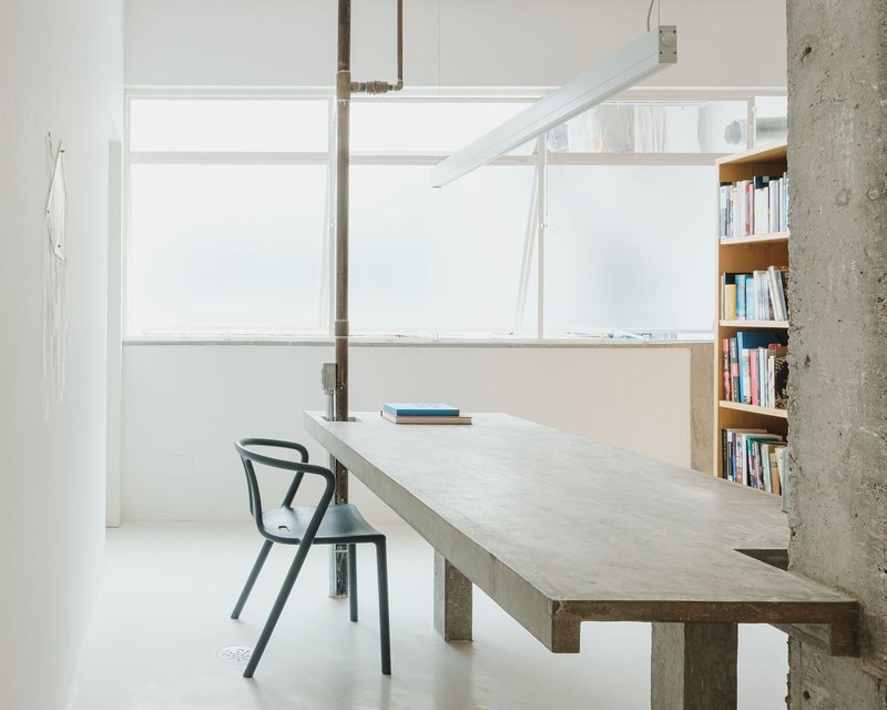 Work table at frosted glass window with steel pipe penetrating the concrete surface
