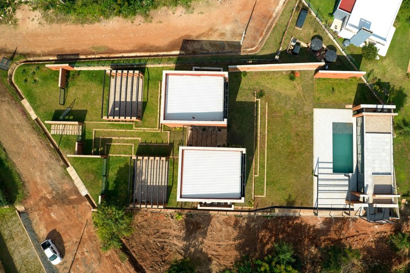 Aerial view of the residence showing rammed earth volumes, green roofs and timber pergolas