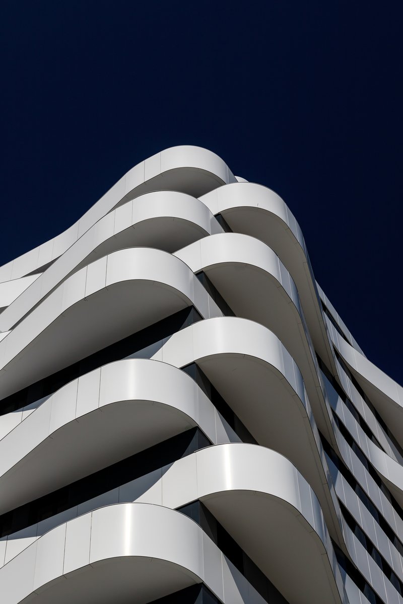 Corner detail of the spiraling white balcony edges against a dark evening sky