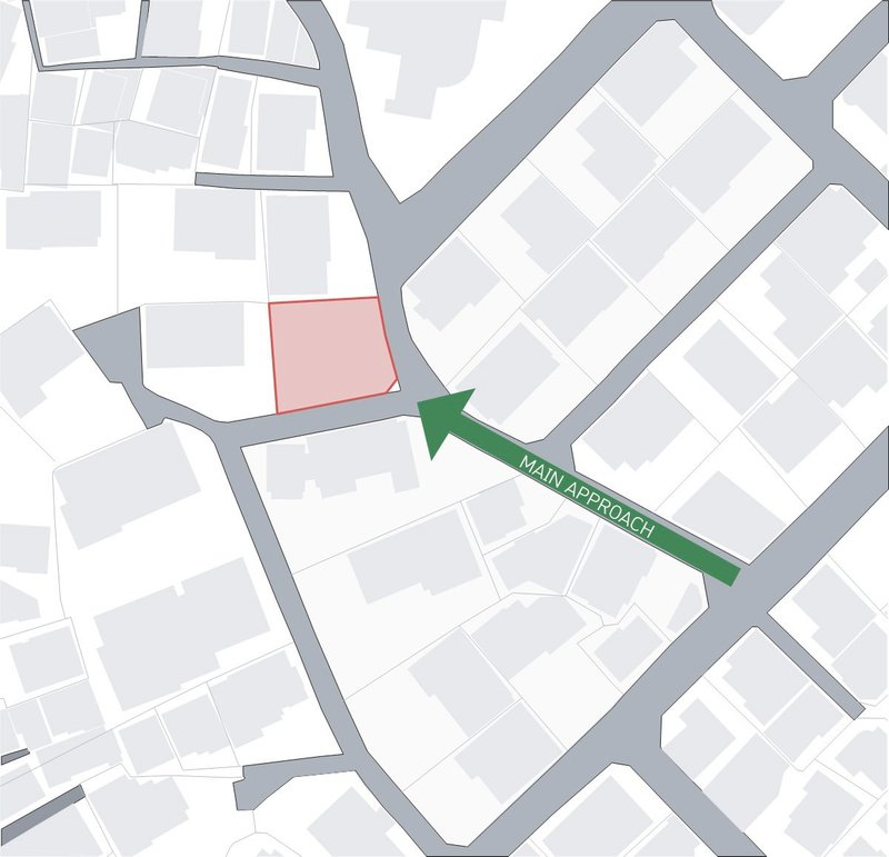 Site plan diagram showing the building footprint in pink and main approach arrow in green