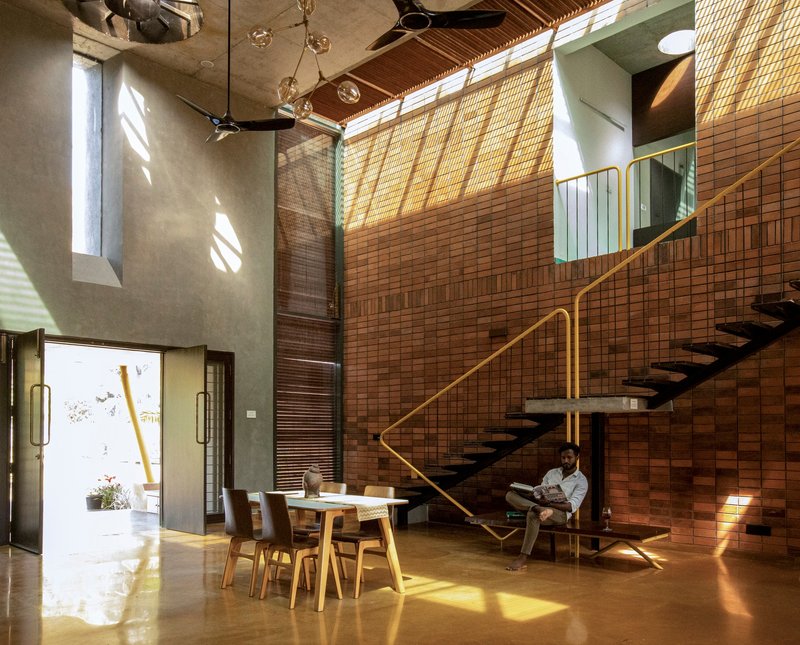 Dining area below the staircase with natural light streaming through clerestory windows
